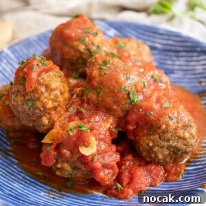Classic Italian Fried Meatballs Recipe — Crispy, Savory Plates 13 Meatballs covered in tomato sauce in a bowl.