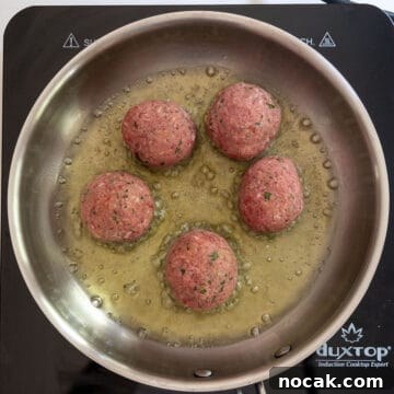 Classic Italian Fried Meatballs Recipe — Crispy, Savory Plates 6 Frying raw meatballs in a saucepan.