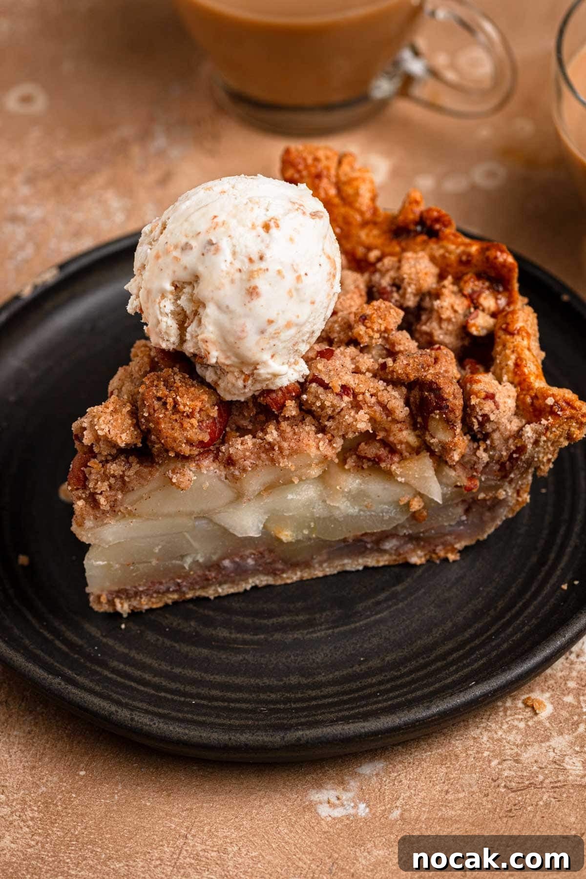A pear pie slice topped with ice cream.