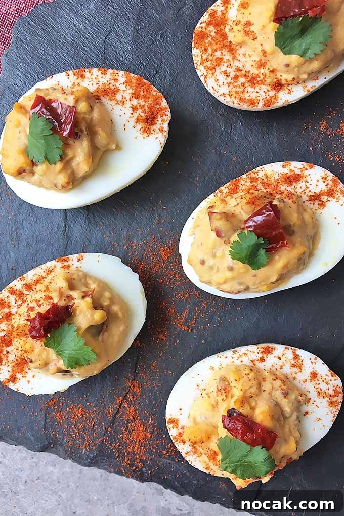 Chipotle Deviled Eggs with Smoky-Spicy Kick 2 Vertical image of a slate of chipotle deviled eggs with a sprinkle of cayenne