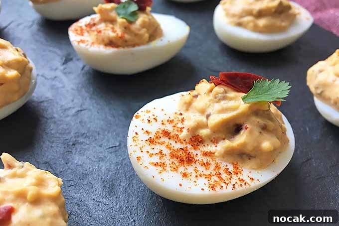 Chipotle Deviled Eggs with Smoky-Spicy Kick 9 Horizontal closeup image of chili pepper egg appetizers on a slate
