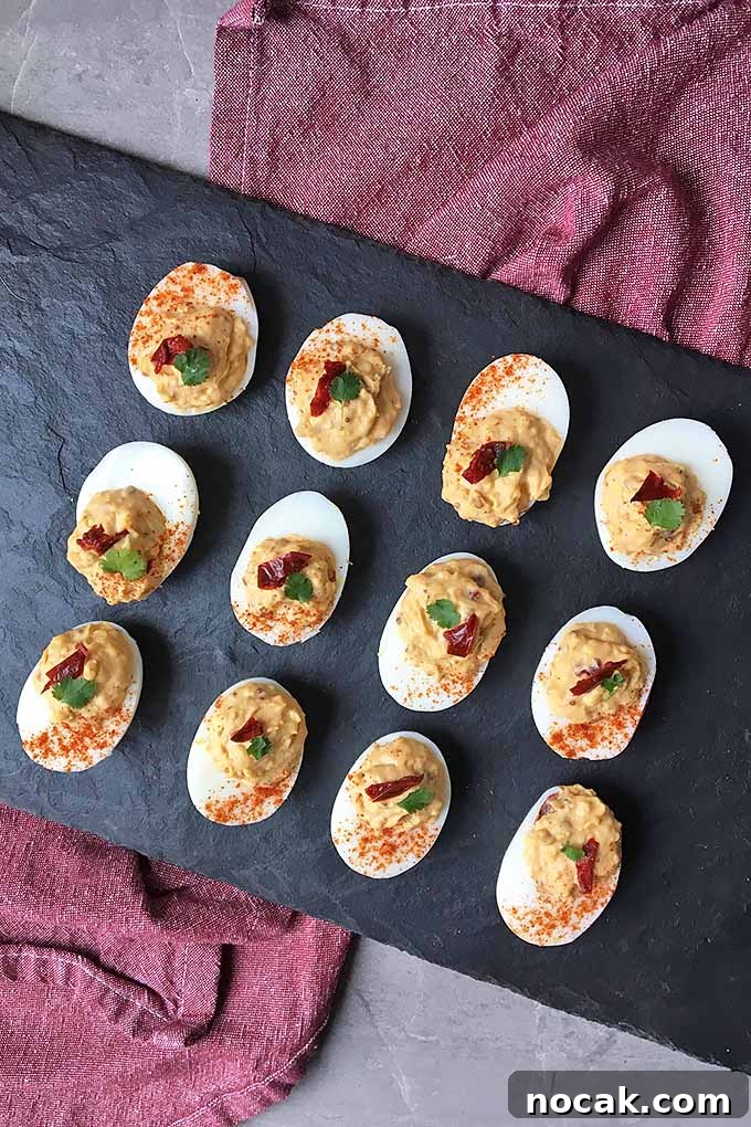 Chipotle Deviled Eggs with Smoky-Spicy Kick 3 Vertical image of a slate tray of deviled eggs on a red towel