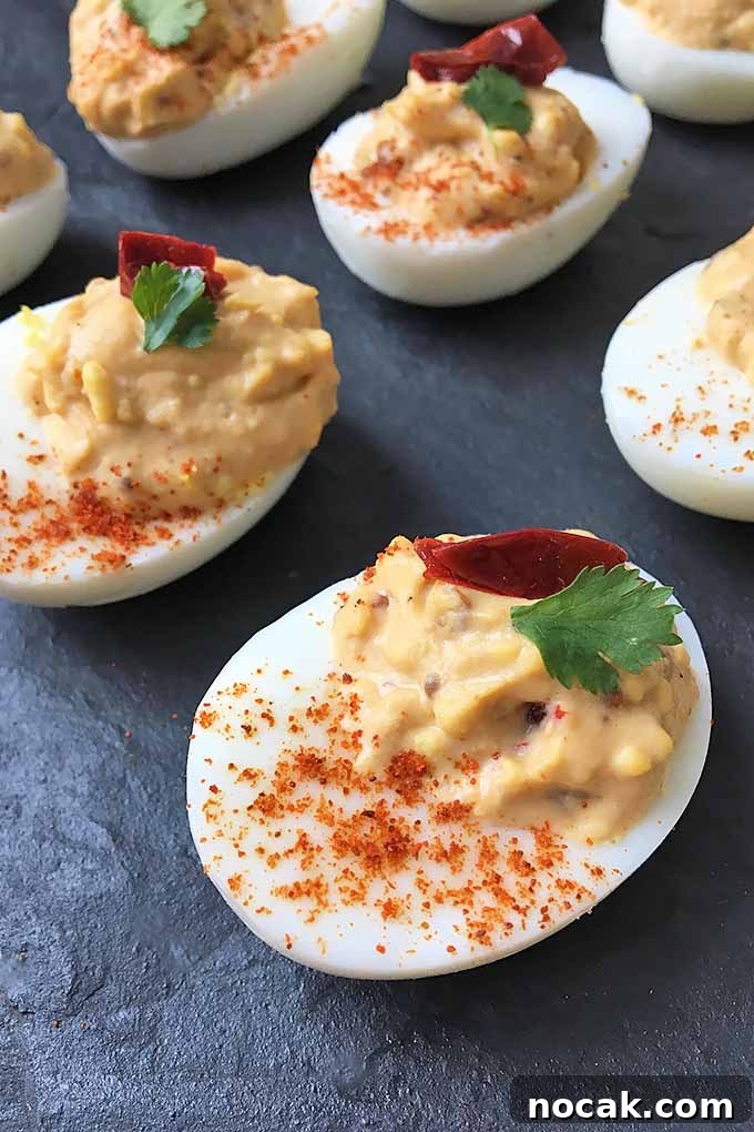 Chipotle Deviled Eggs with Smoky-Spicy Kick 4 Vertical image of chili pepper egg appetizers on a plate