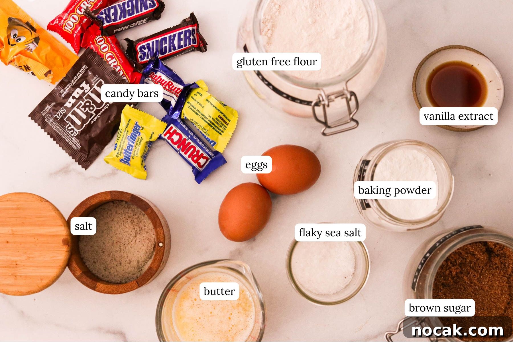 Leftover Halloween Candy Cookie Bars Recipe for Using Candy Up 3 Ingredients for leftover Halloween candy cookie bars including candy bars, gluten free flour, vanilla extract, baking powder, flaky sea salt, eggs, salt, butter, and brown sugar.