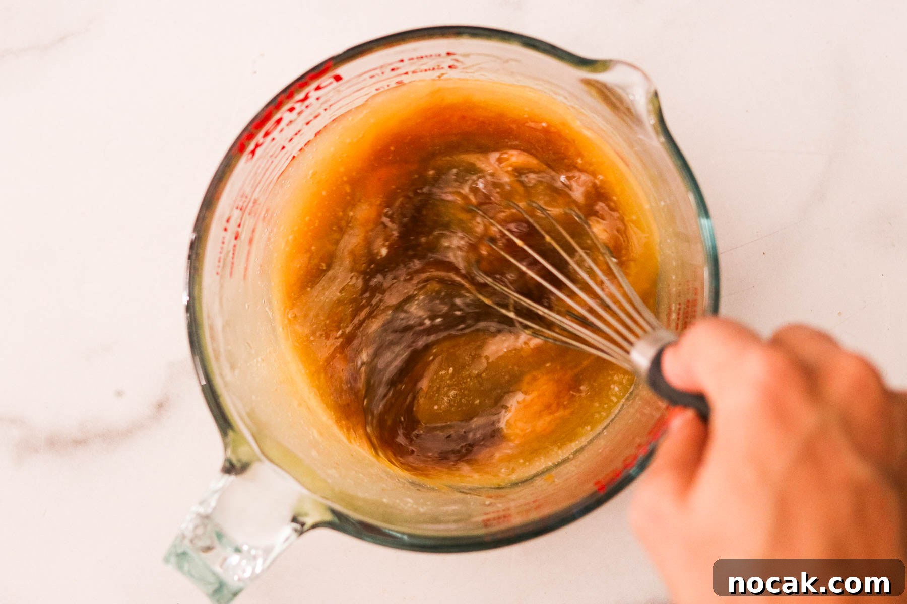 Leftover Halloween Candy Cookie Bars Recipe for Using Candy Up 5 Butter, brown sugar, egg, egg yolk, and vanilla extract in a glass measuring cup being whisked together.