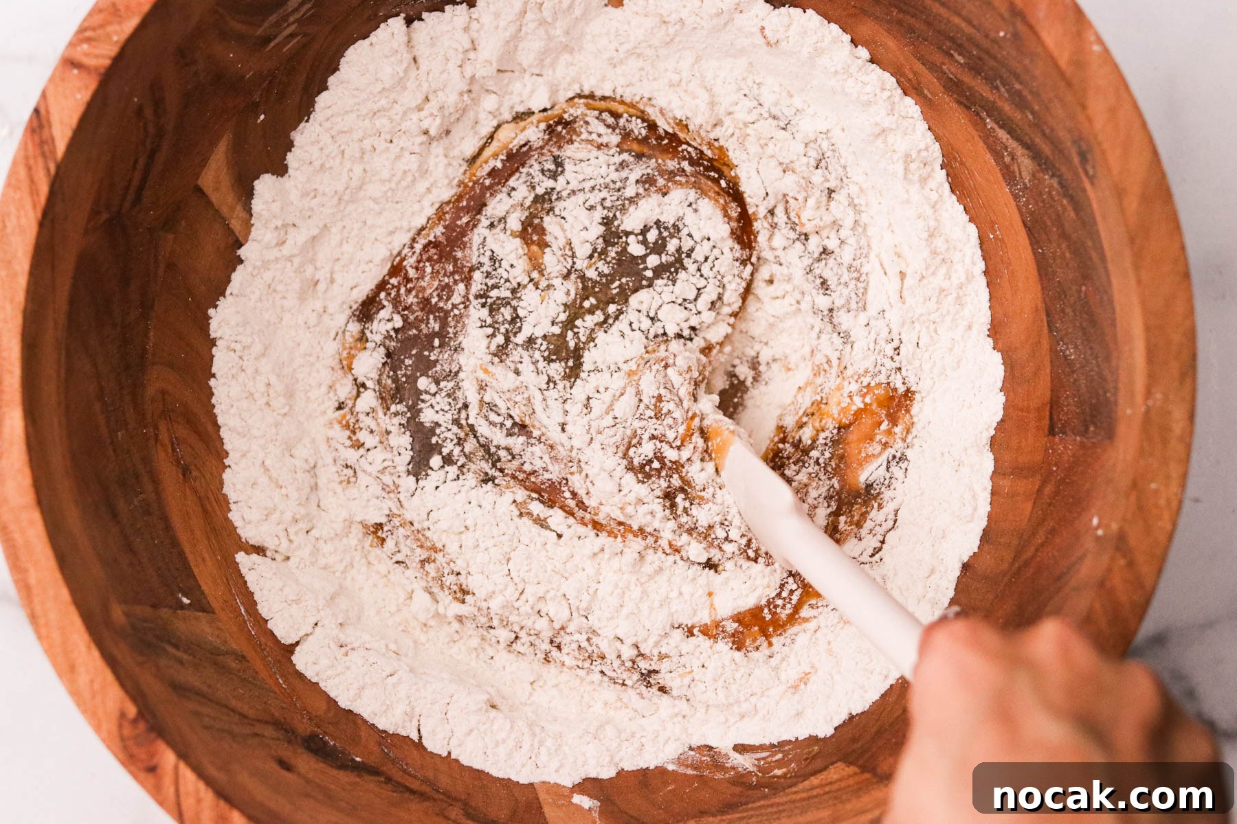 Leftover Halloween Candy Cookie Bars Recipe for Using Candy Up 6 Wet ingredients being stirred into the dry mixture in a large wooden bowl.