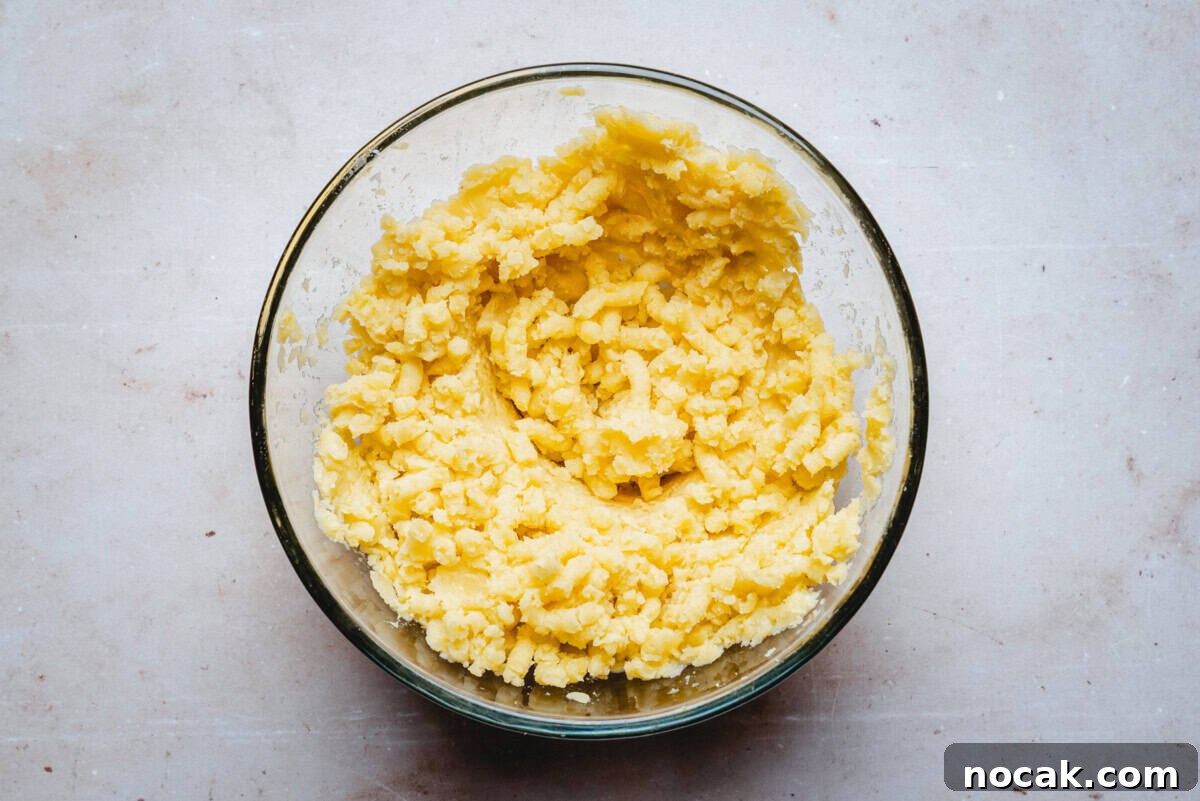Creamy Horseradish Mashed Potatoes Recipe for Flavorful Sides 8 A glass bowl filled with freshly mashed potatoes sits on a light-colored countertop. The mashed potatoes appear creamy with a slightly lumpy texture.