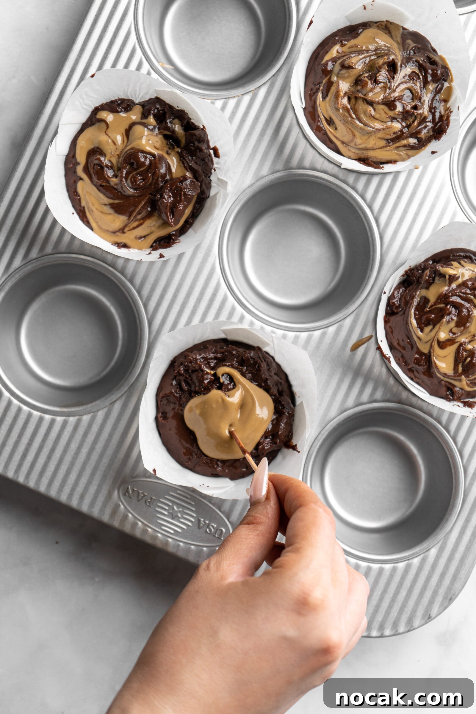 Bakery-Style Double Chocolate Chip Muffins with SunButter Swirl 5 Swirling Sunbutter into bakery style double chocolate chip muffin batter.