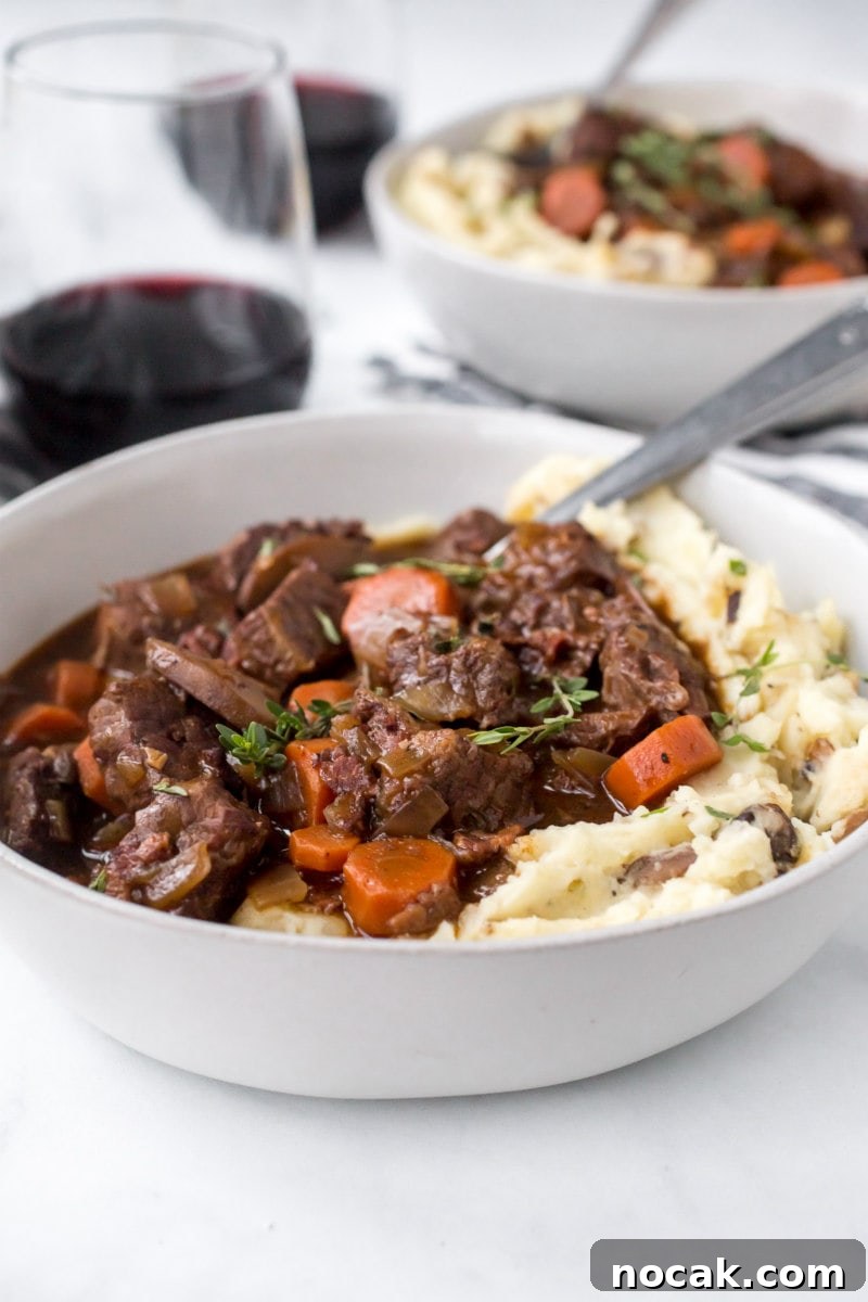 Instant Pot Beef Bourguignon serving of beef bourguignon with mashed potato in a white bowl