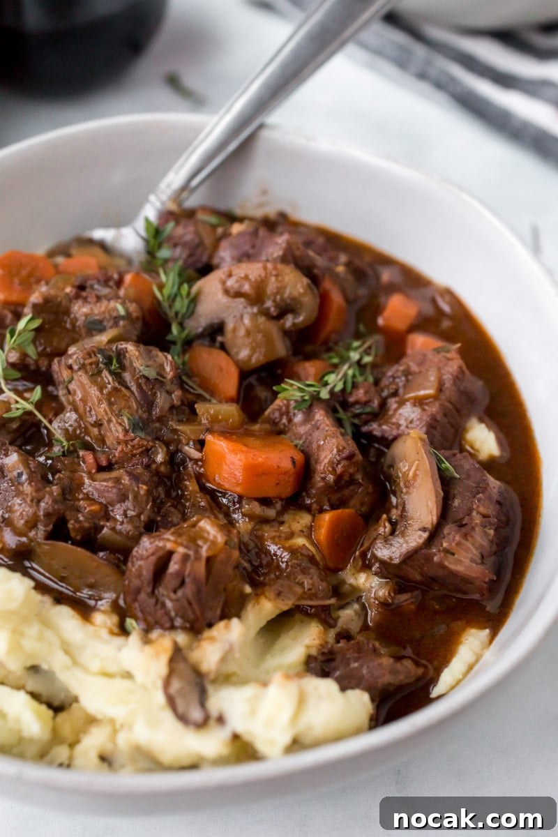 Instant Pot Beef Bourguignon serving of beef bourguignon with potato in a white bowl