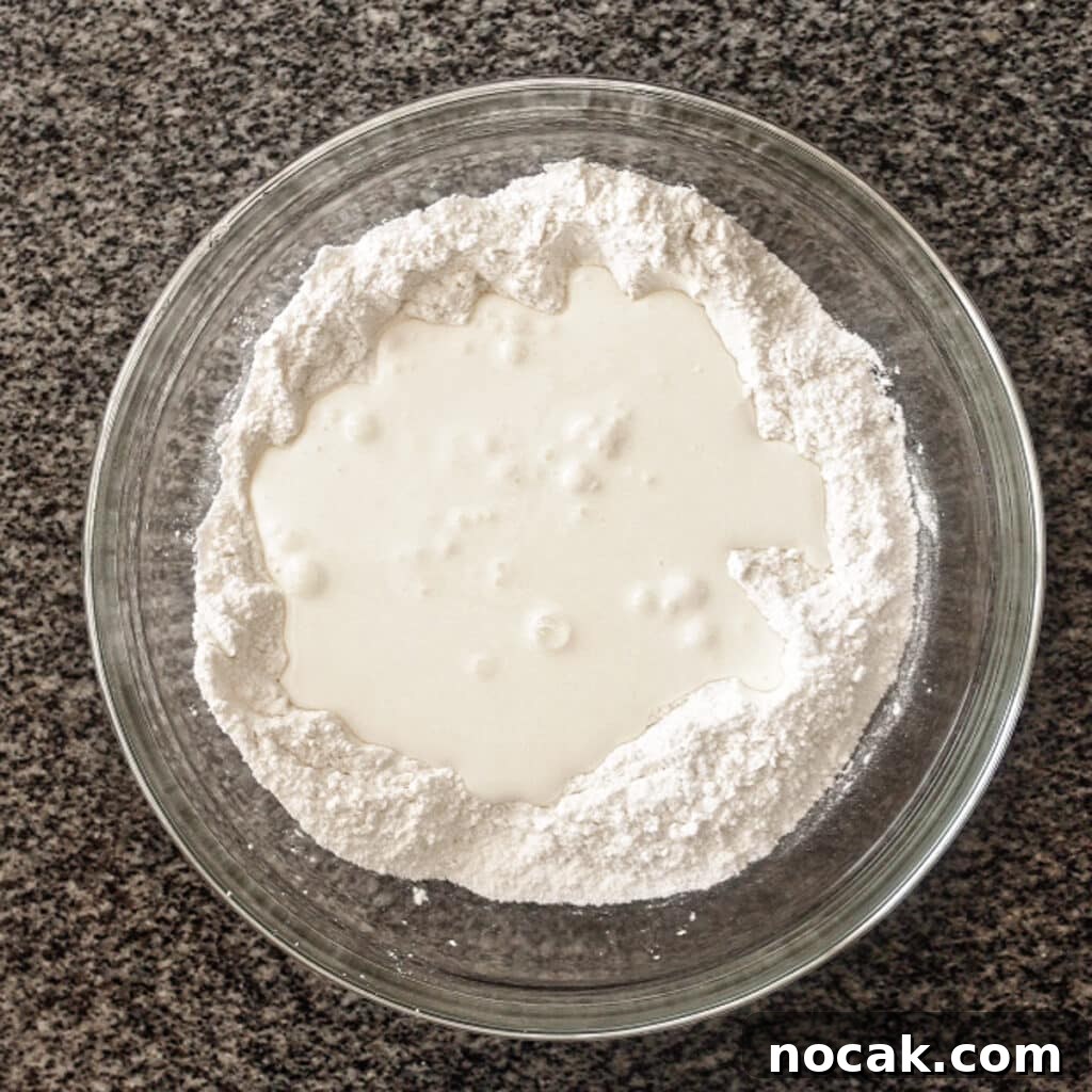 making a well in flour mixture and pouring buttermilk into well