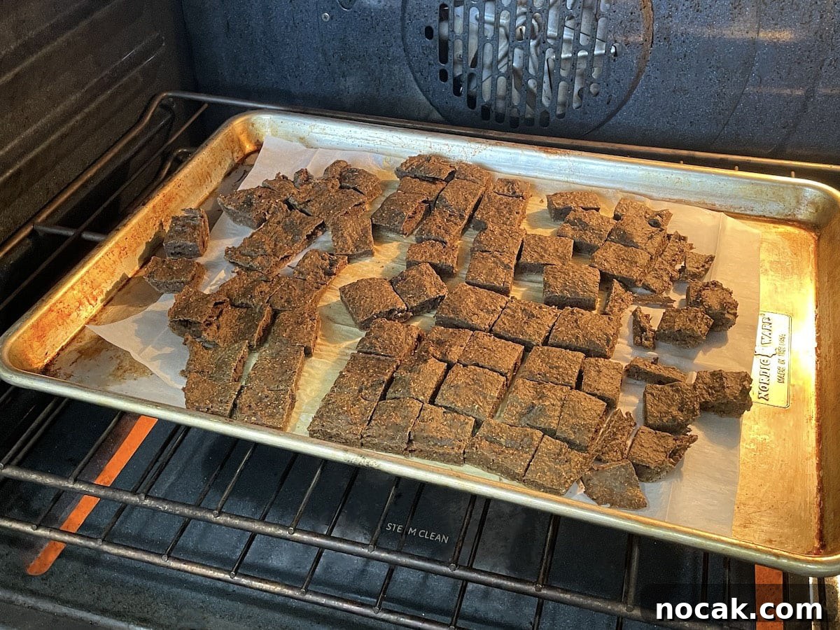 Homemade Liver Brownies: Irresistible Dog Treat Recipe 7 Cut liver treats on parchment paper baking in the oven.