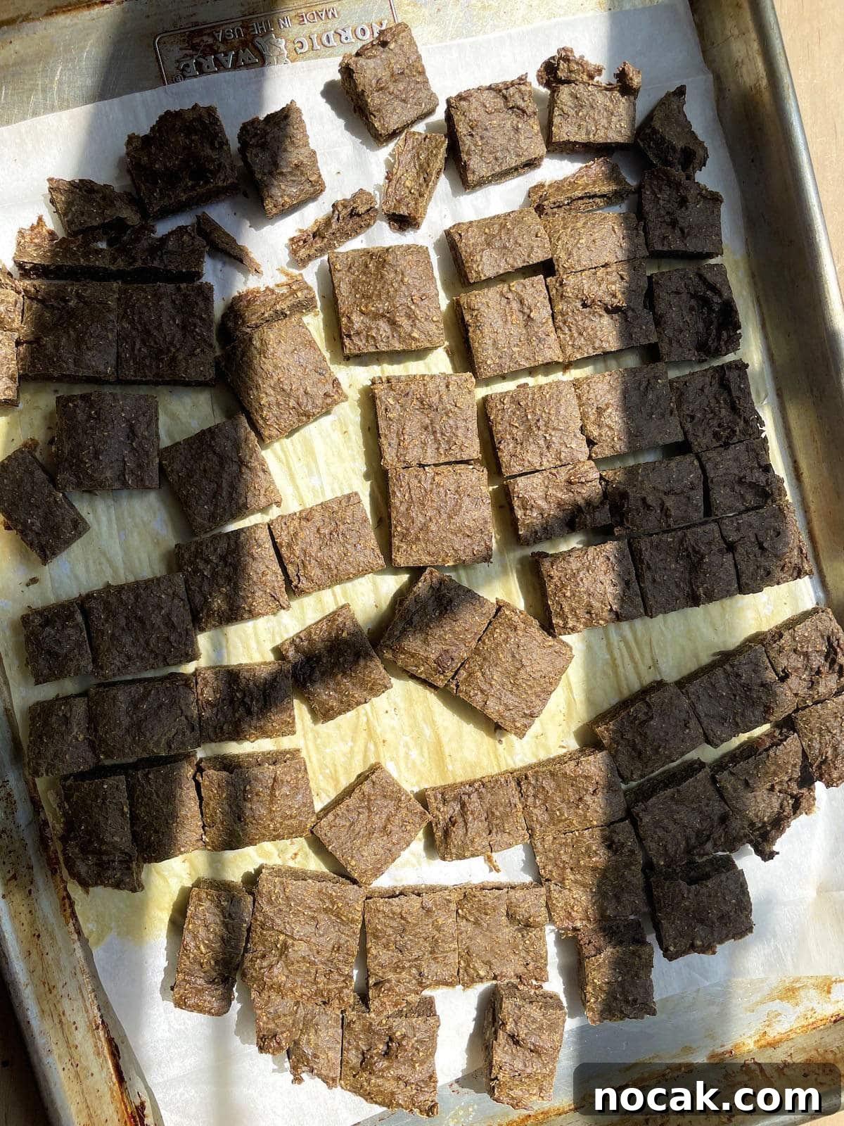 Homemade Liver Brownies: Irresistible Dog Treat Recipe 8 A baking sheet with parchment paper on it showing baked liver brownies for dogs.
