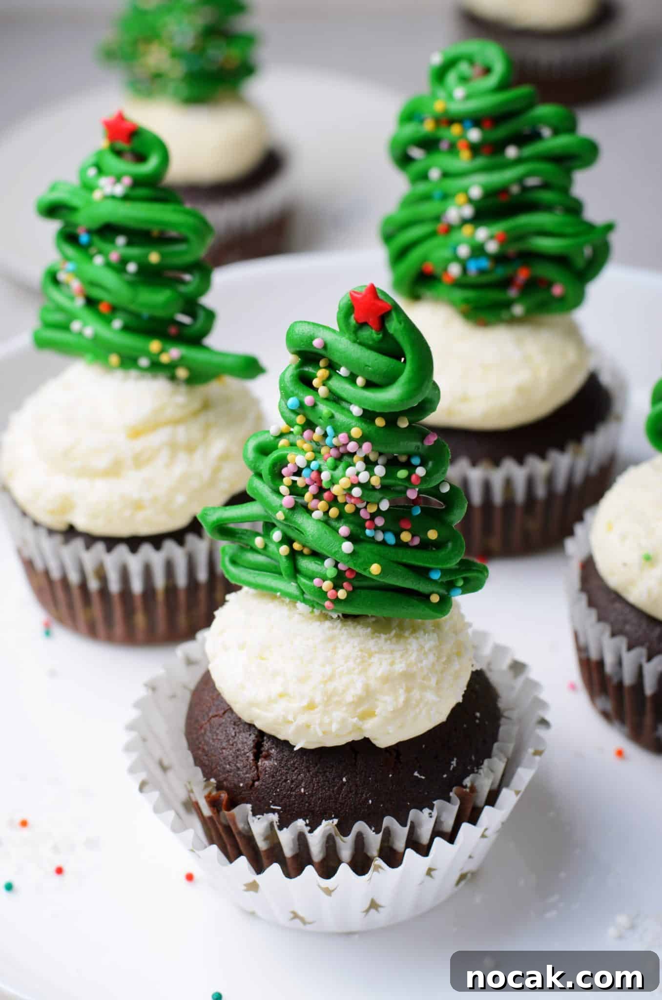 Chocolate Christmas Tree Cupcakes with Vanilla Buttercream Frosting 2 Cake stand filled with four Chocolate cupcakes with vanilla buttercream frosting and topped with a chocolate christmas tree topper.