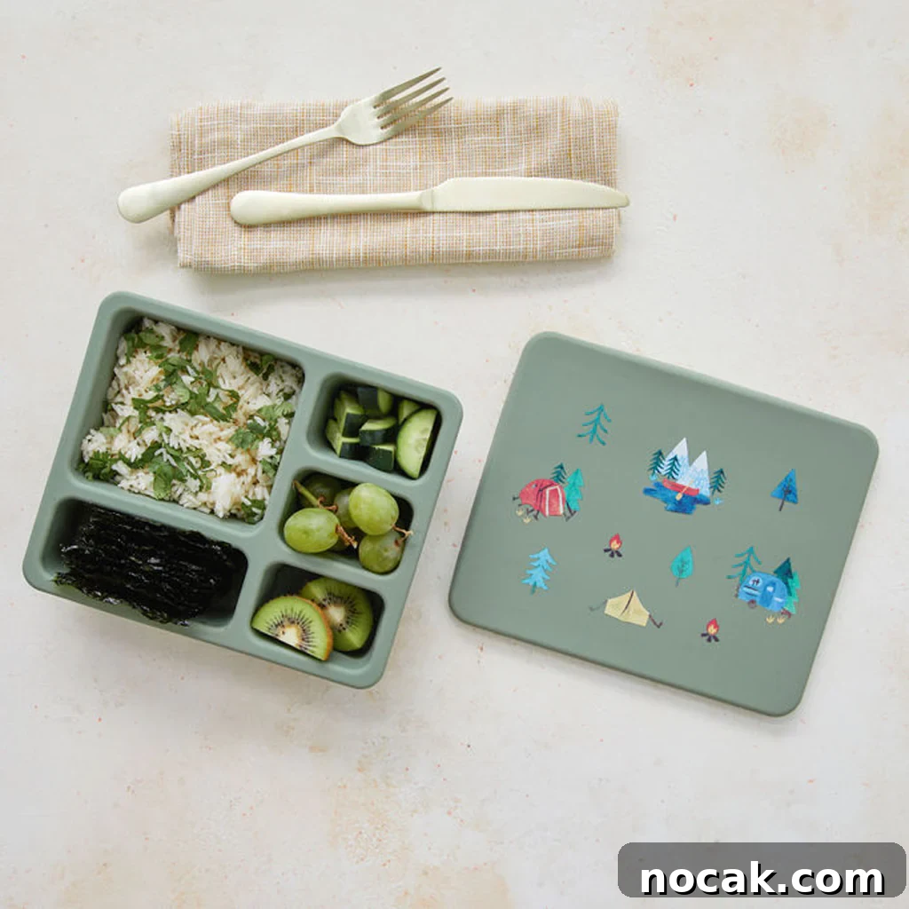 Open silicone bento box showing sections with rice, veggies, and fruit