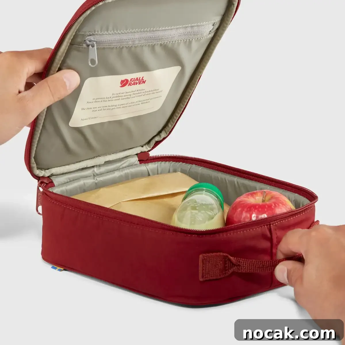 Maroon Kånken Mini Cooler, open with a drink and apple inside