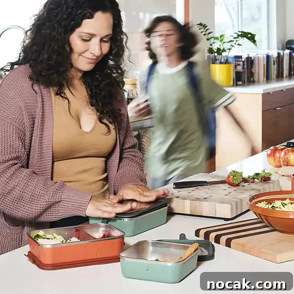 A parent packing a child's lunch with stainless steel bento boxes