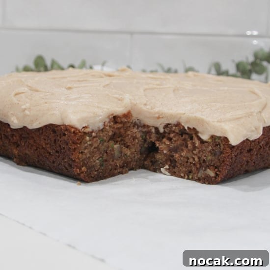 Zucchini Dessert Bars can be frosted with your favorite topping, frosting, or not at all. A corner piece removed from a scrumptious cake.
