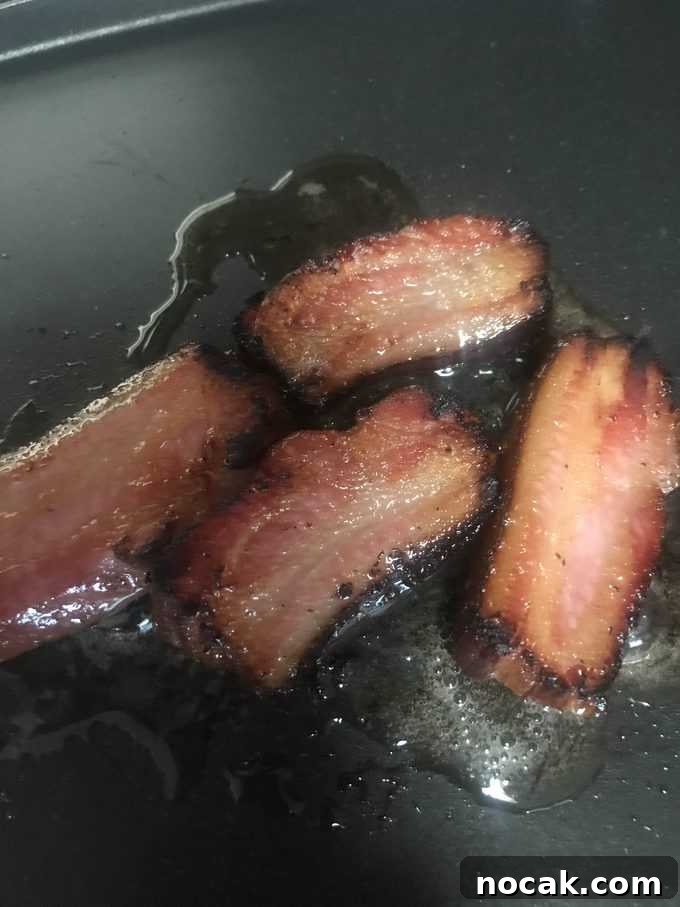 Homemade Hickory-Smoked Bacon Recipe: How to Make Real Bacon 3 bacon sizling in pan | savorwithjennifer.com