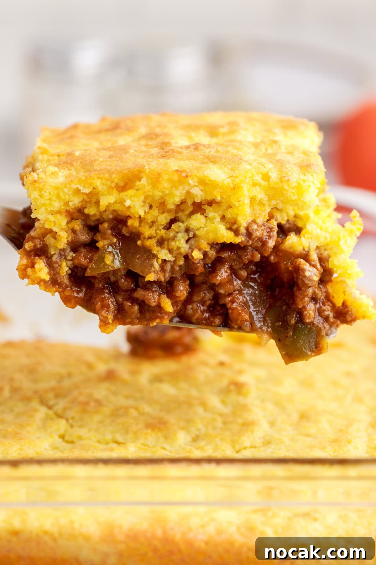 Sloppy Joe Casserole with Cheesy Cornbread Topping 2 lifting spatula of Sloppy Joe Cornbread Casserole