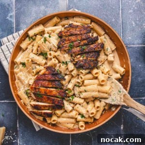 Blackened Chicken Alfredo Pasta Recipe: Creamy Cajun-Style Dinner 10 Chicken alfredo with blackened seasoning in a pan on a flat surface.