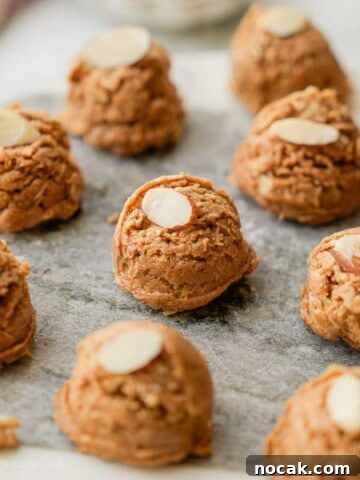 Almond butter protein bite on marble with almond slice.