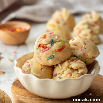 Edible Sugar Cookie Dough Recipe — Egg-Free & Safe to Eat 14 Scoops of edible sugar cookie dough in bowl with sprinkles.