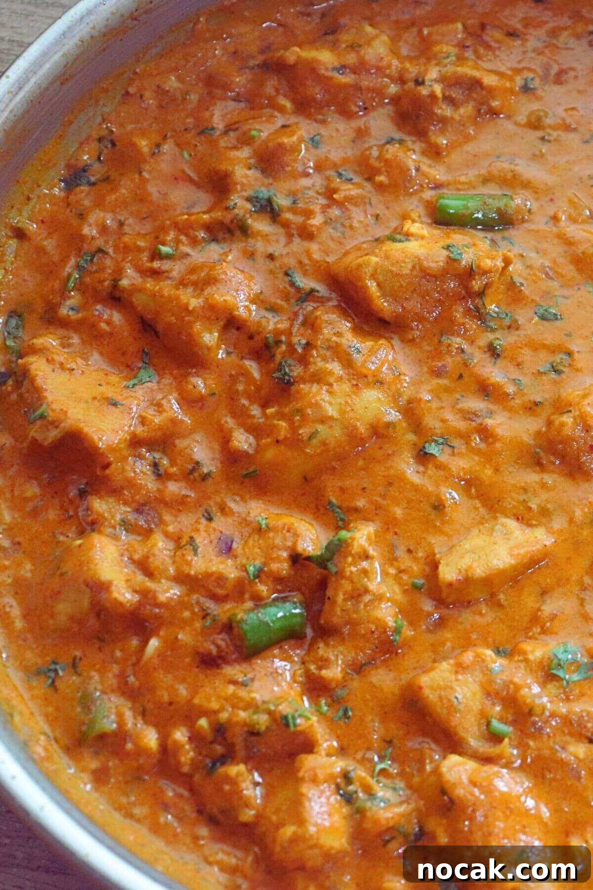 Garlic Chicken Curry (Lehsuni Murgh) Recipe — Aromatic Indian Dish 2 garlic chicken curry in a skillet. Garnished with coriander leaves.