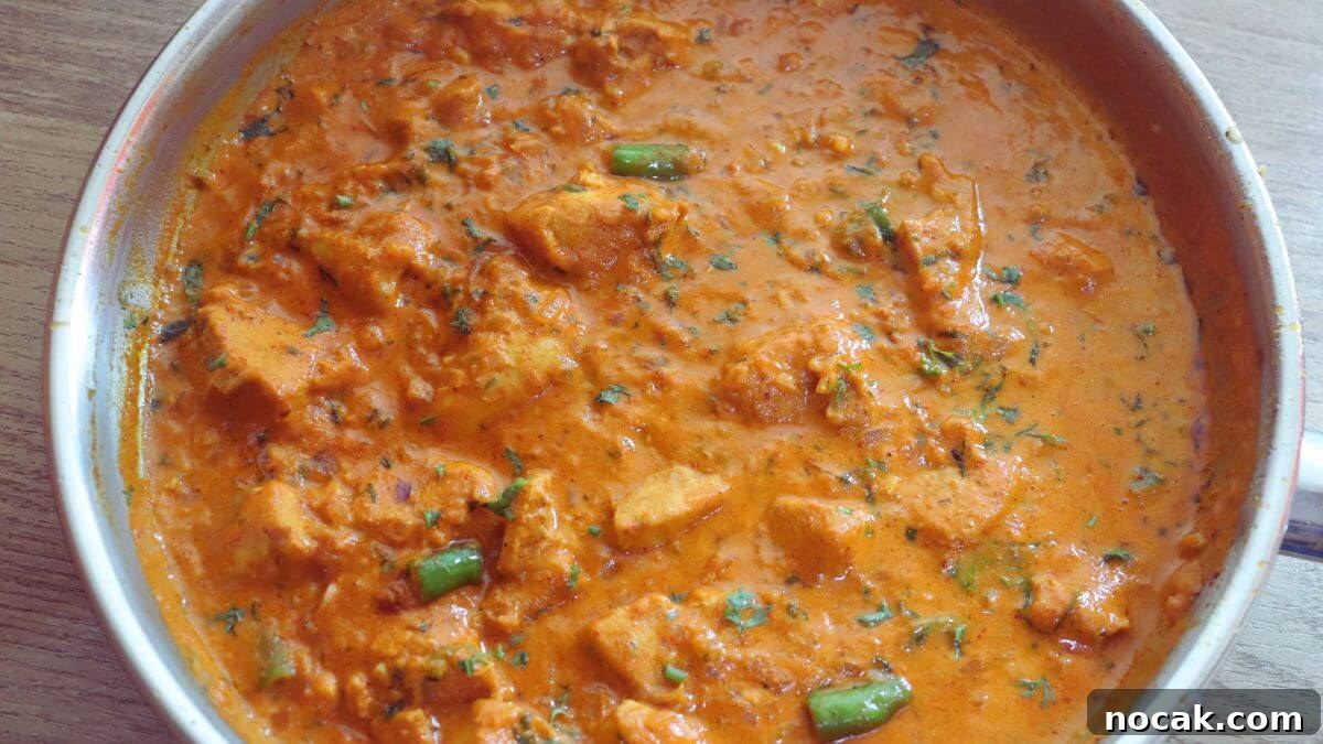 Garlic Chicken Curry (Lehsuni Murgh) Recipe — Aromatic Indian Dish 11 garlic chicken curry in a pan. Garnished with coriander leaves.