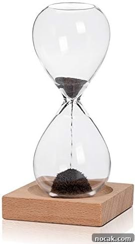 2025 Holiday Gift Guide: Top Picks for Every Recipient 21 A glass hourglass filled with black sand sits on a square wooden base.