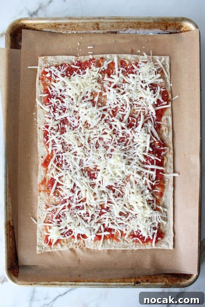 High-Protein Lavash Pizza Ready in 10 Minutes 5 A process shot of lavash bread pizza with lavash bread topped with sauce and cheese.