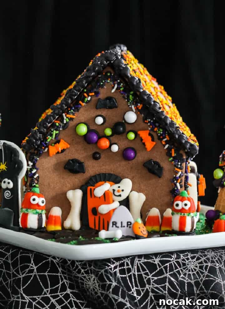 A Halloween gingerbread house decorated with candy and royal icing.