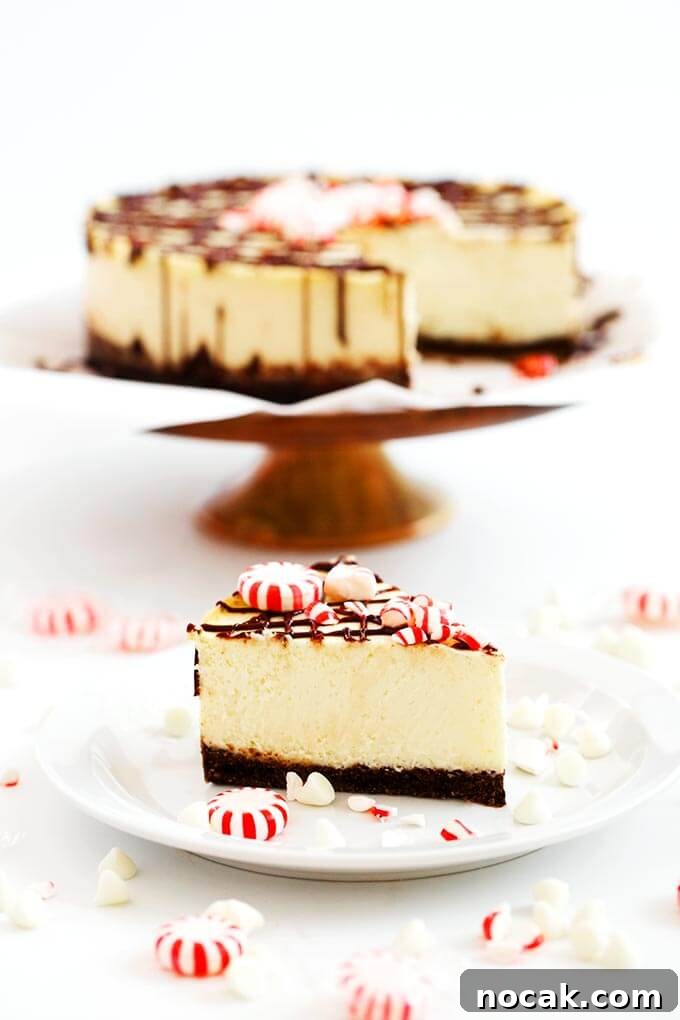 Thanksgiving Recipes for Instant Pot: Fast Holiday Favorites 21 Slice of White Chocolate Peppermint on a white plate in front of rest of cheesecake on a cake stand