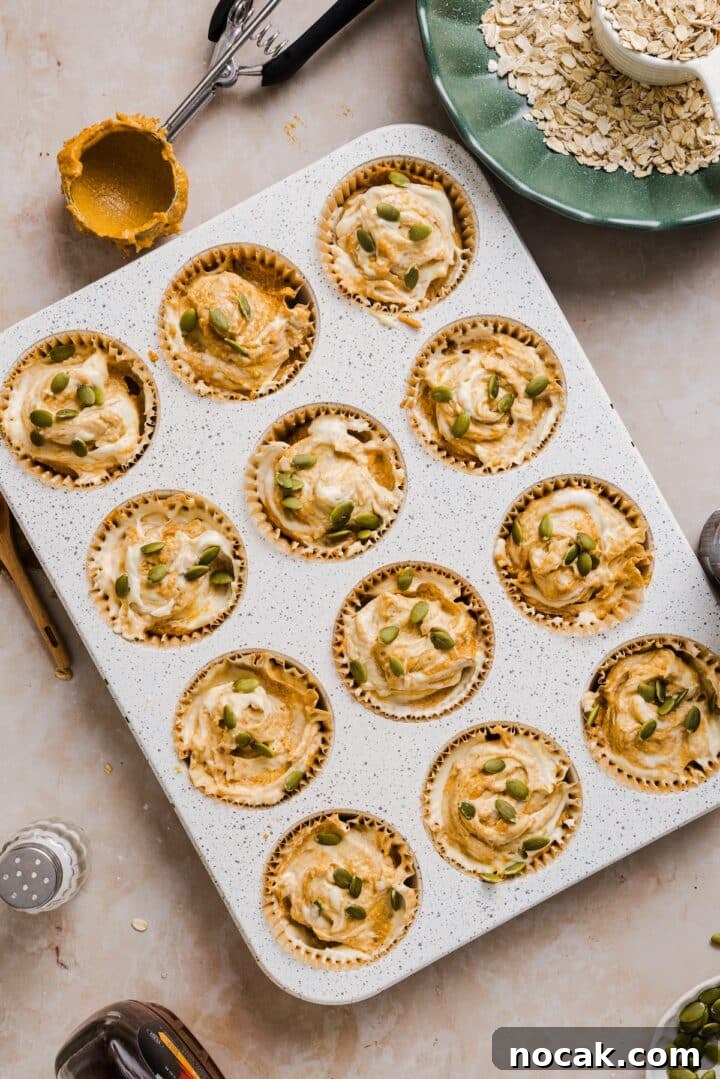 Pumpkin Cream Cheese Muffins with Swirled Filling and Spice 7 Raw pumpkin cream cheese muffins with pepitas.