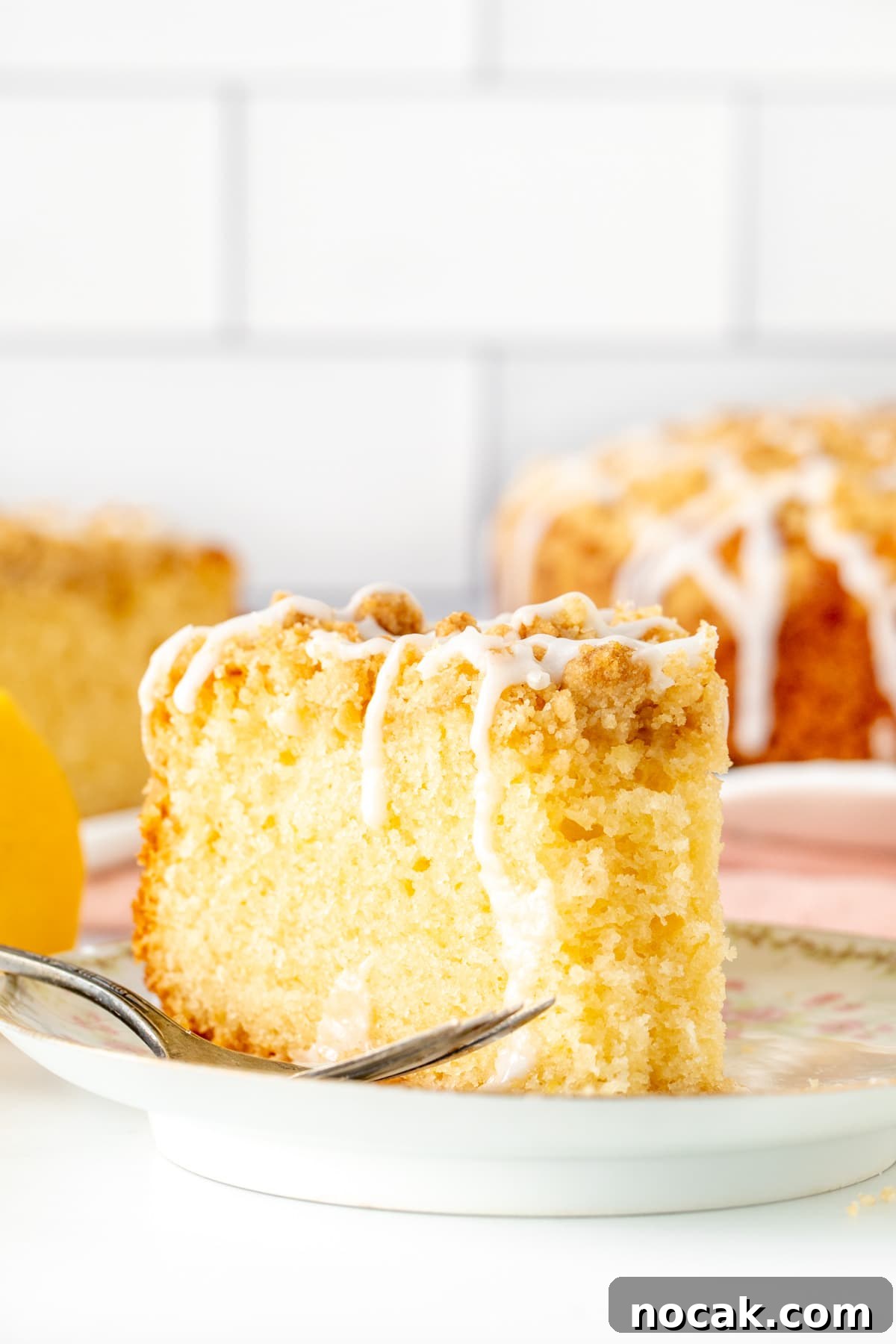 Lemon Coffee Cake Recipe: Moist Citrus Bundt Cake for Brunch 10 Slice of lemon coffee cake with crumb topping with a bite taken out