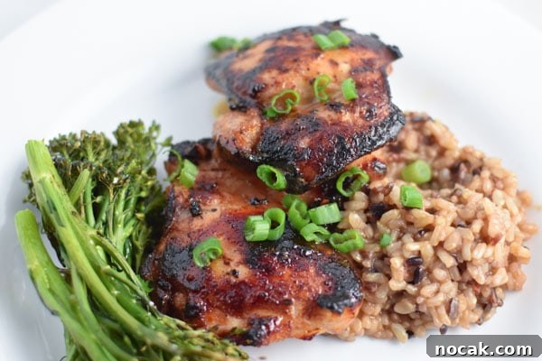 Sticky Honey Garlic Chicken Dinner Recipe 3 Honey garlic chicken thighs with rice and broccolini, topped with green onions, on a white plate