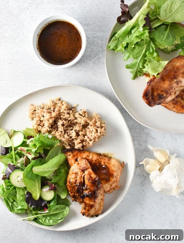 Sticky Honey Garlic Chicken Dinner Recipe 4 Two plates of garlic chicken with sauce, a simple salad, and rice