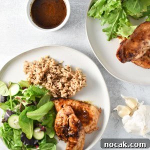 Two plates of garlic chicken with sauce, a simple salad, and rice