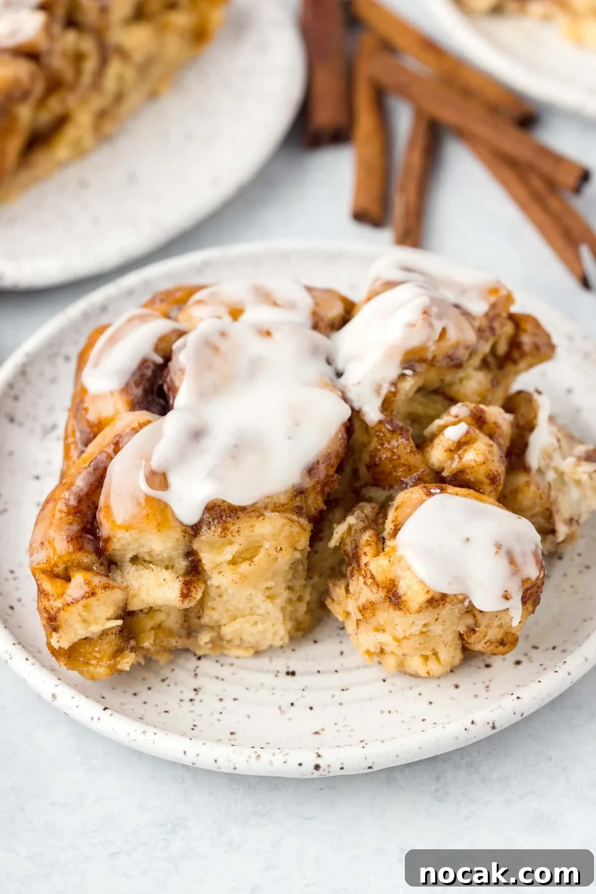 Cinnamon Roll Casserole Breakfast Bake Recipe 2 A cinnamon roll on a plate, topped with icing.