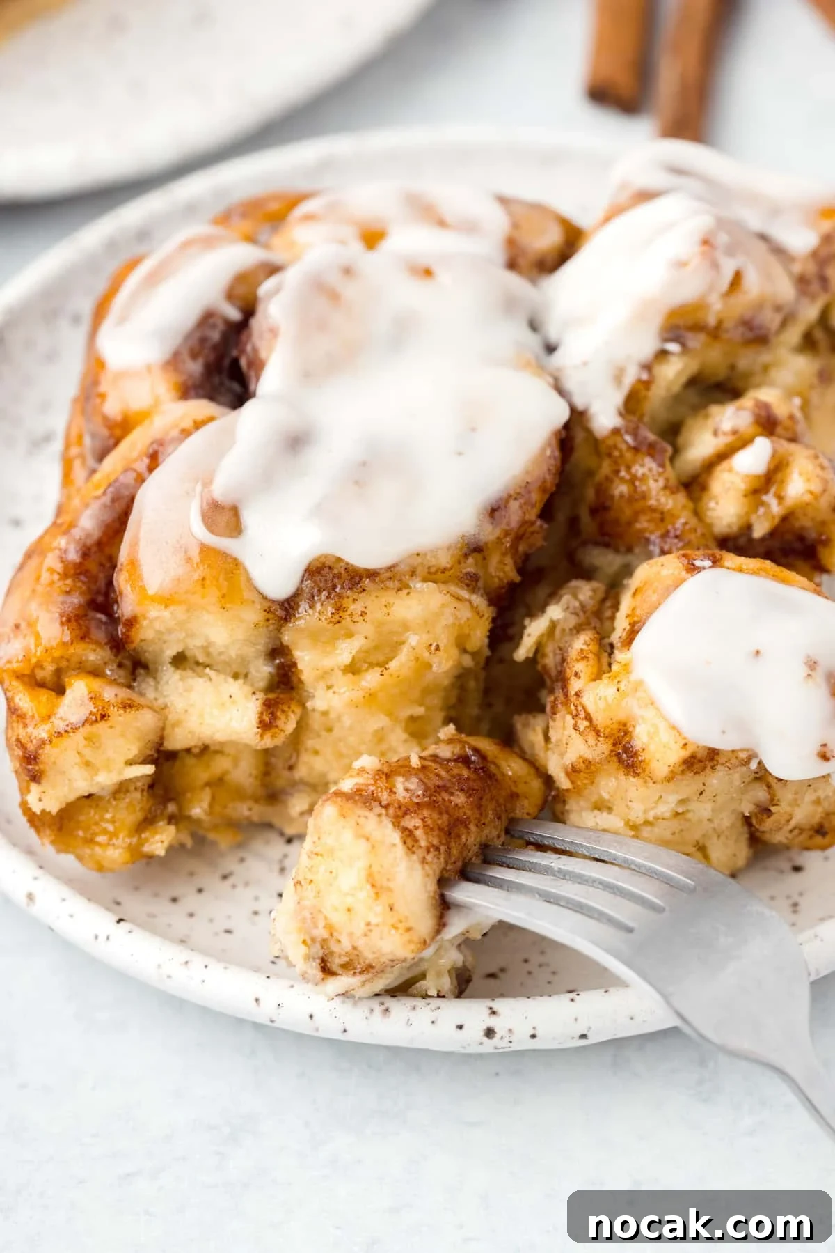 Cinnamon Roll Casserole Breakfast Bake Recipe 13 A fork taking a portion from a cinnamon roll.