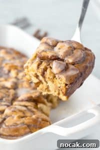 Cinnamon Roll Casserole Breakfast Bake Recipe 25 Lifting a portion of cinnamon roll breakfast bake from a baking dish.