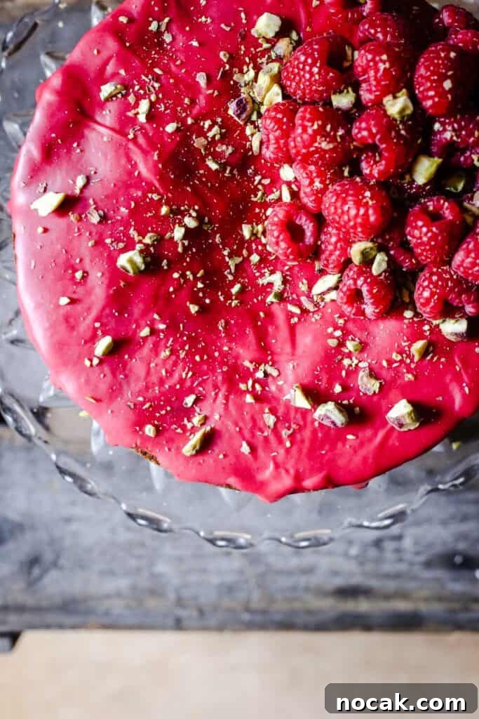Gluten-Free Raspberry and Pistachio Cake Recipe 3 Raspberry Pistachio Cake sitting on a cake stand on a wooden table
