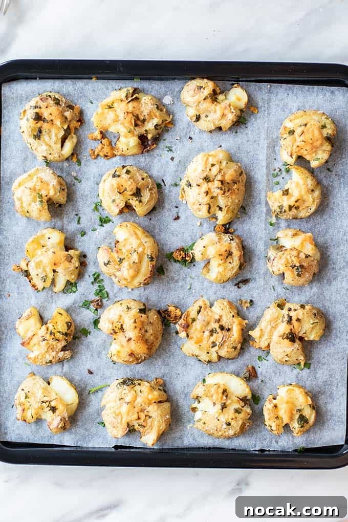 Crispy Parmesan Oven-Baked Smashed Potatoes 6 A baking tray with smashed potatoes in rows.