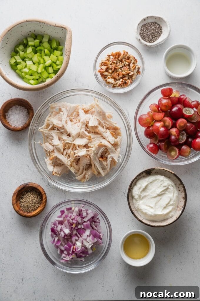 Sun-Drenched Sonoma Chicken Salad with Grapes & Almonds 3 Flatlay with bowls of shredded chicken, red grapes, chopped celery and red onion, Greek yogurt, apple cider vinegar, honey, salt, and pepper.
