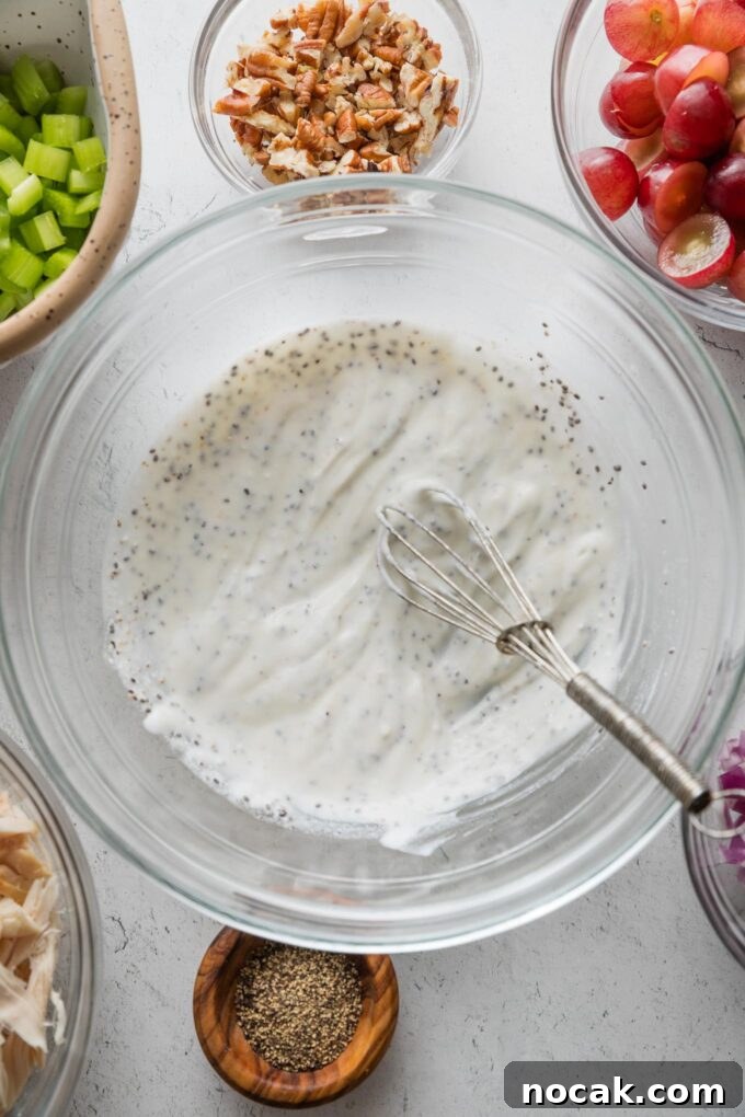 Sun-Drenched Sonoma Chicken Salad with Grapes & Almonds 4 Greek yogurt-based dressing for chicken salad mixed together in a large glass prep bowl.