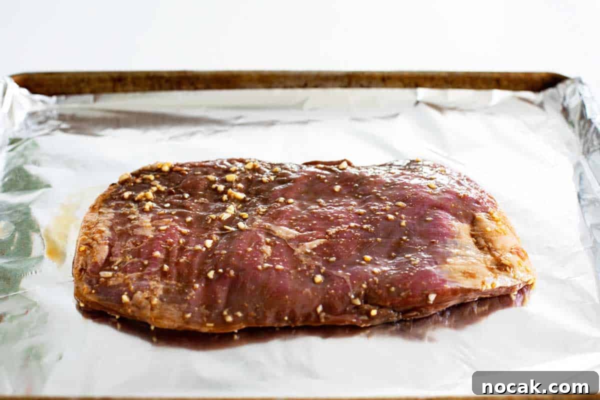 Flank Steak Marinade marinated flank steak on a baking sheet