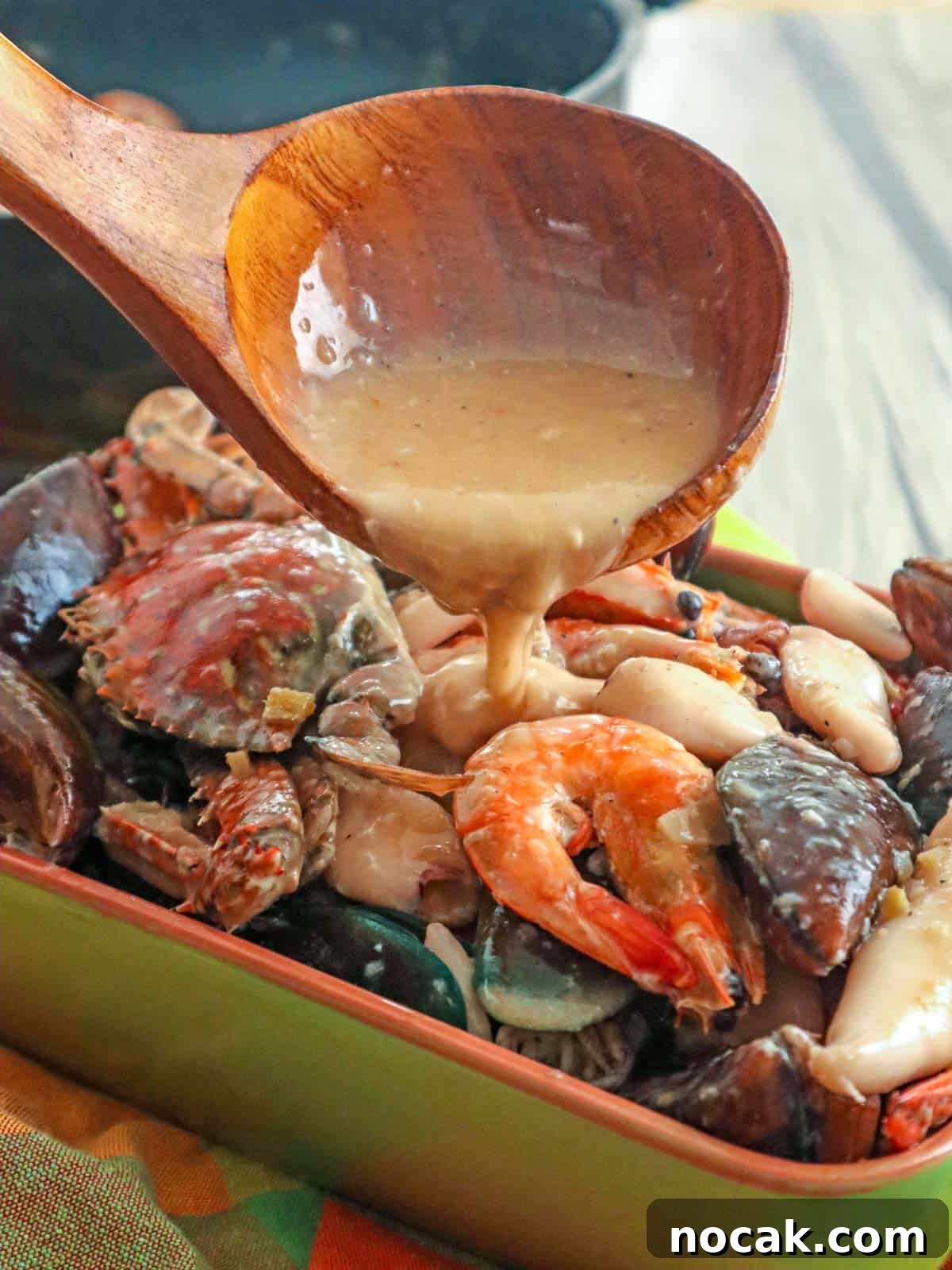 Seafood in Coconut Milk (Ginataang Seafood) Recipe 8 pouring coconut sauce over ginataang seafood in serving dish