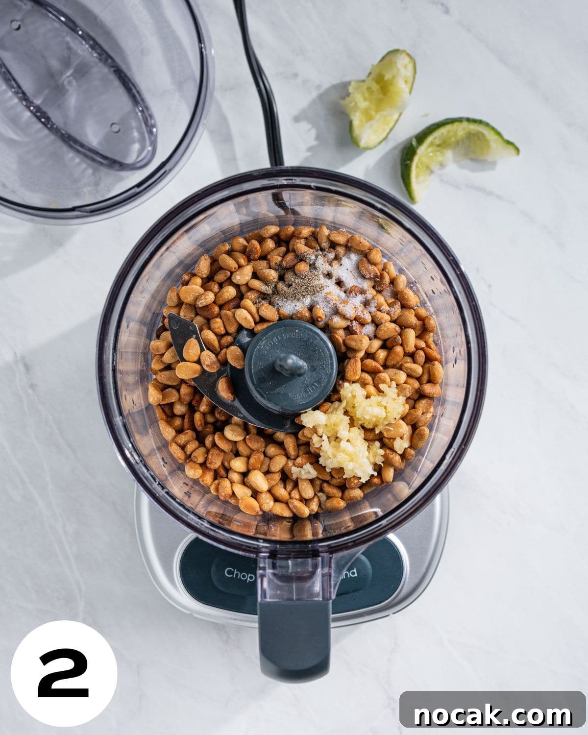 Step 2: Food processor with toasted pine nuts, lime, salt, pepper, and minced garlic.