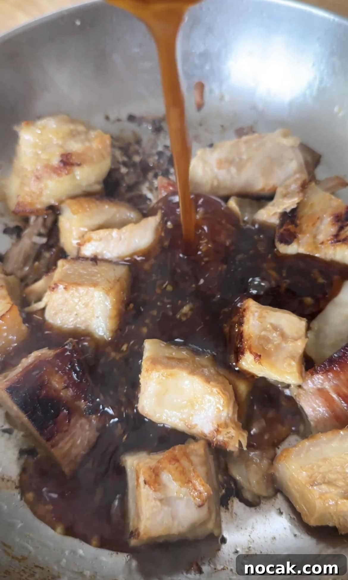 adding sauce to the pork belly chunks.