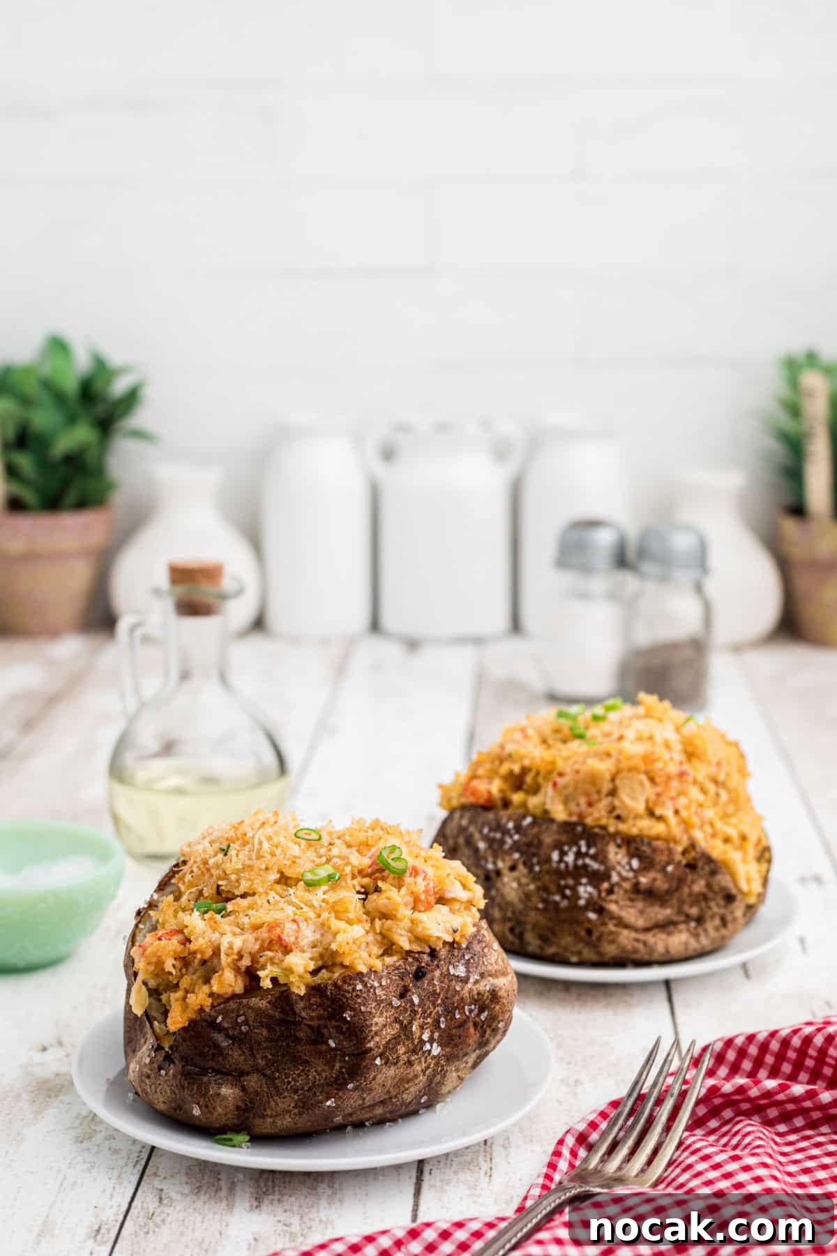 Crawfish-Stuffed Baked Potato Recipe 8 Side shot of two crawfish baked potato on plates.